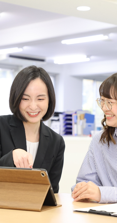 2人の女性がタブレットを操作しながら話している様子