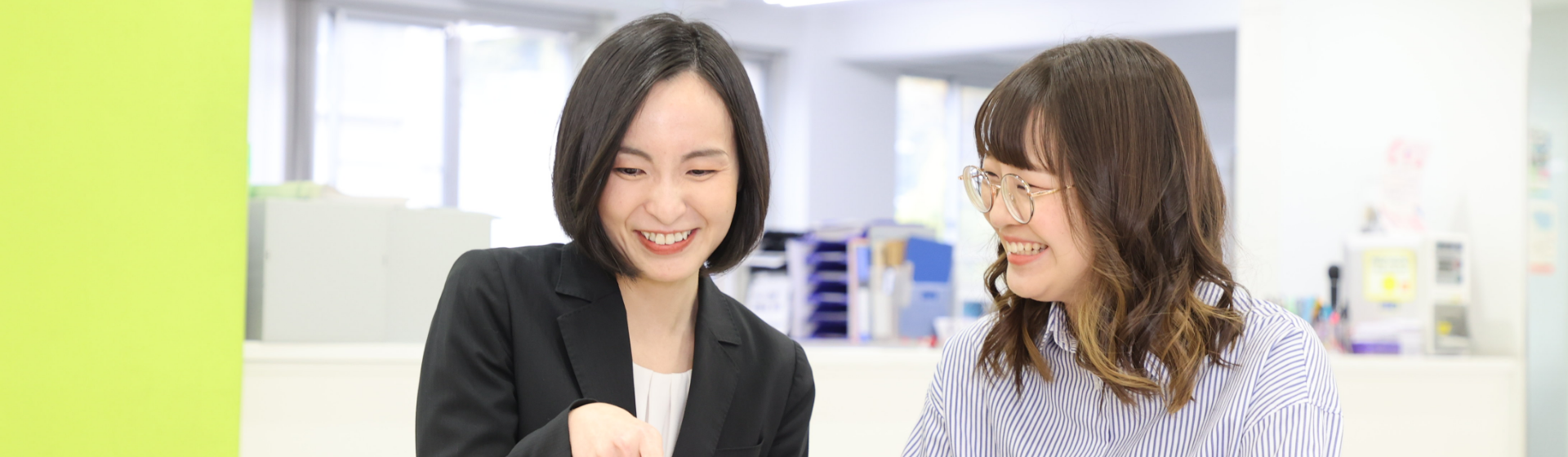 2人の女性がタブレットを操作しながら話している様子