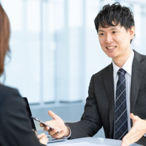 スーツ姿の男性が、女性に何かを説明している様子