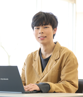 デスクでノートパソコンを操作する男性の様子