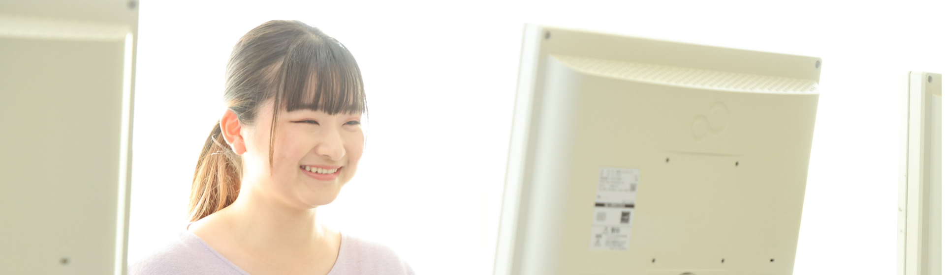 笑顔でパソコンを操作している女性の様子